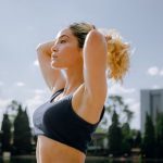 Fit woman in a black tank top enjoys a sunny workout outdoors in Ciudad de México, embracing wellness and healthy living.